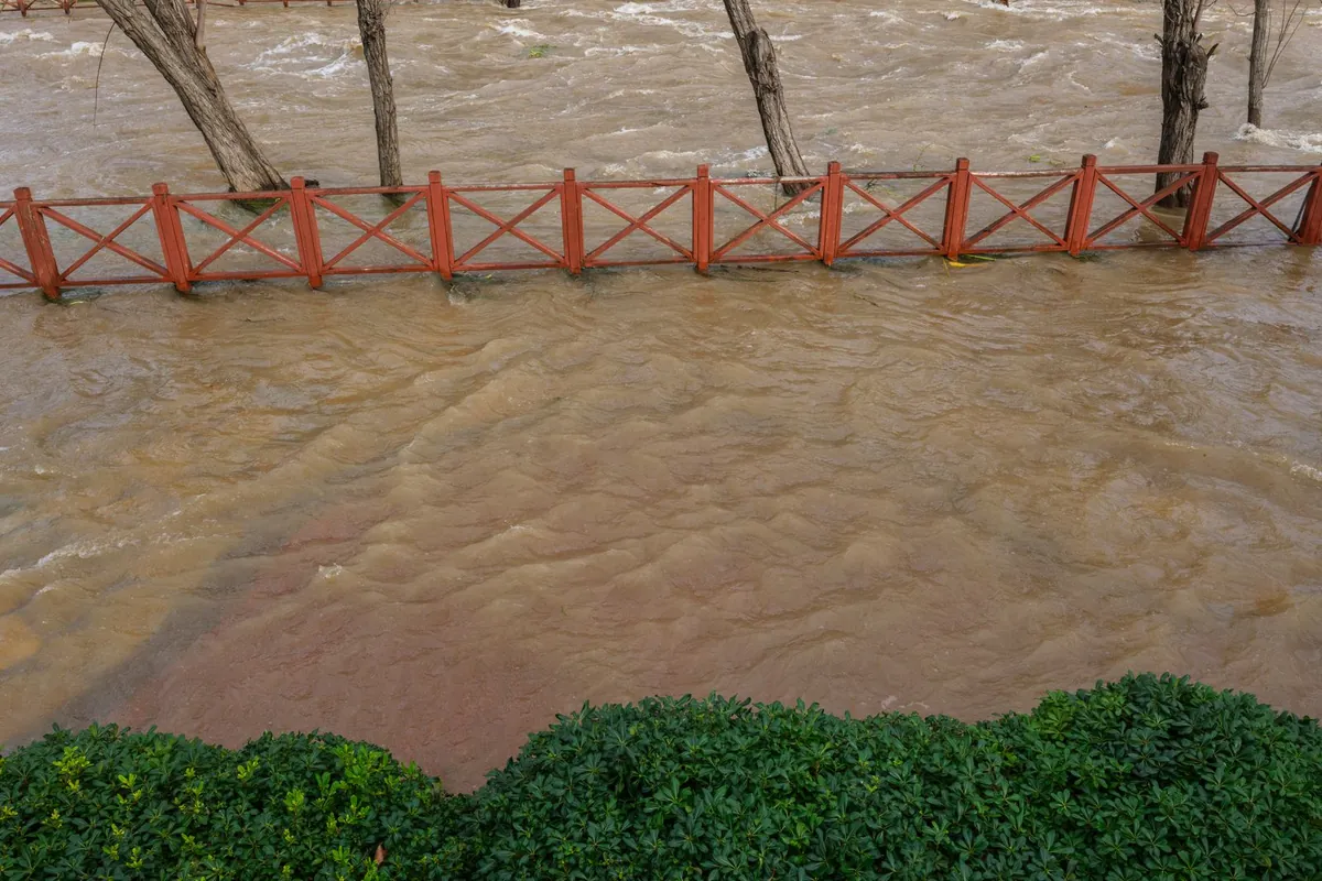 Eau boueuse en crue qui recouvre un bord de rivière