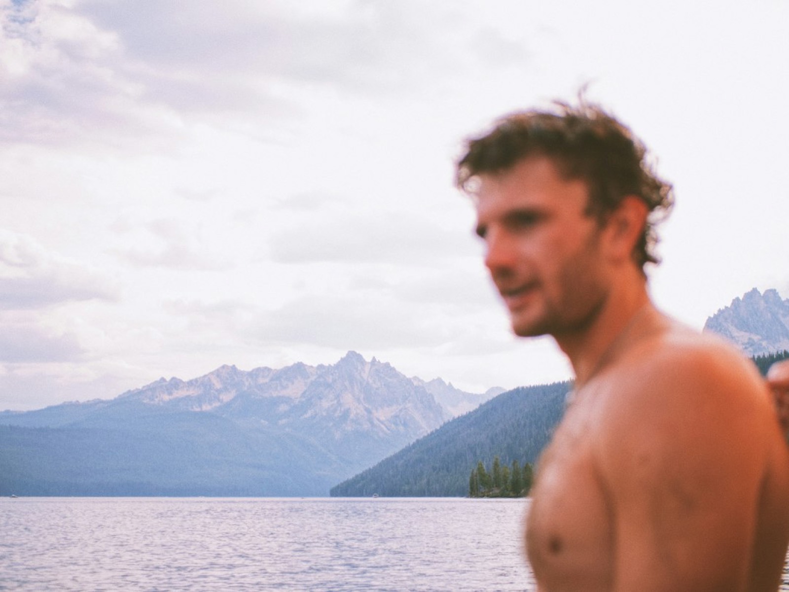 Homme en short de bain au bord d'un lac en été