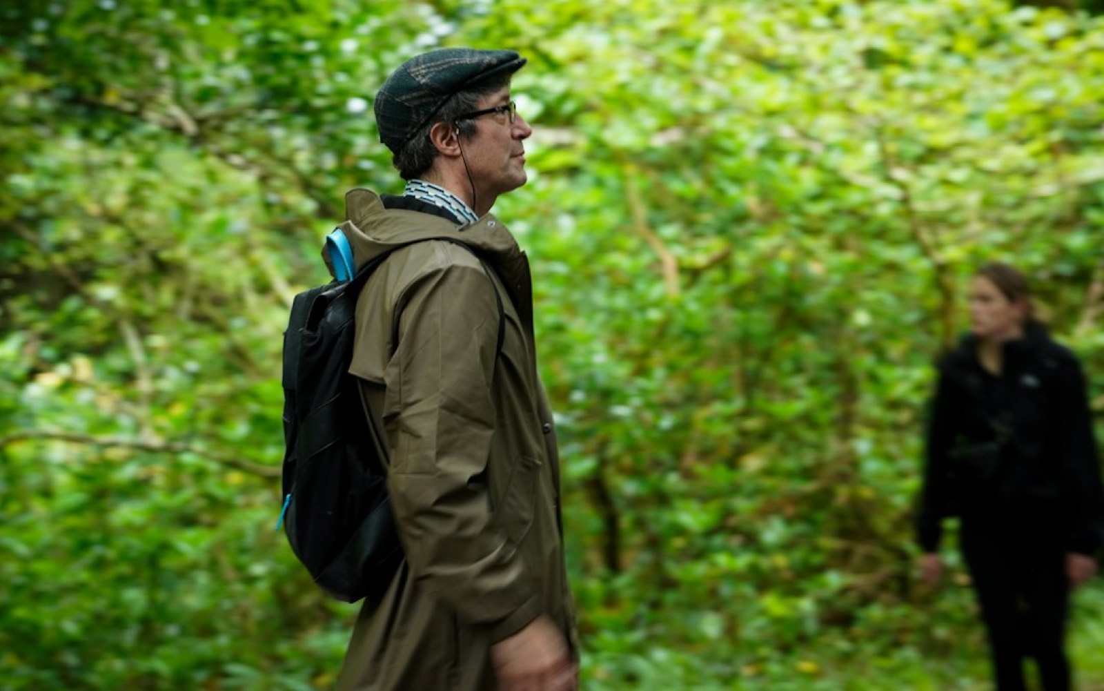 Homme en veste de pluie lors d'une marche en forêt